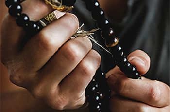 close up of hands holding black beads